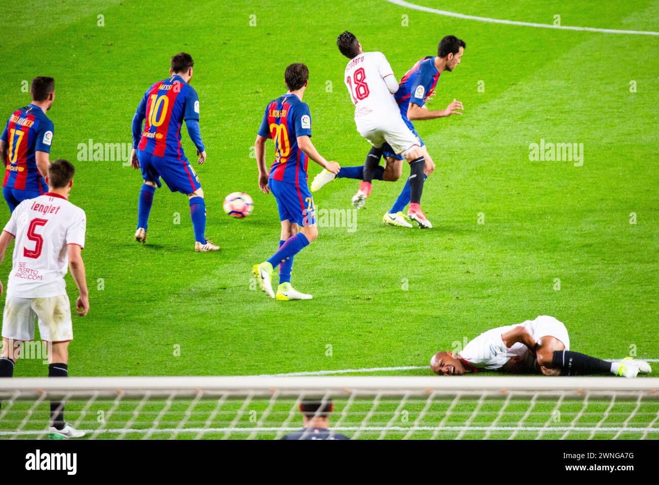 SERGIO BUSQUETS, UGLY TACKLE, BARCELONA FC, 2017: The game turns ugly as Sergio Busquets goes into a bruising tackle with Sergio Escudero as another Sevilla player Nzonzi lies on the ground clutching his groin. Barcelona FC v Sevilla FC at Camp Nou, Barcelona on 5 April 2017. Photo: Rob Watkins. Barca won the game 3-0 with three goals in the first 33 minutes. The game was played in a deluge of rain during a massive spring storm. Stock Photo