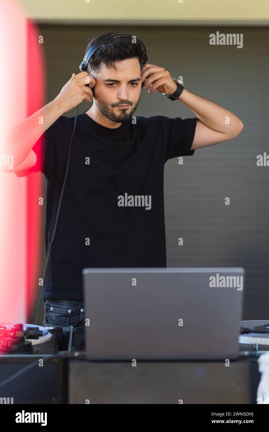 DJ listening to music while letting the laptop playback. Stock Photo