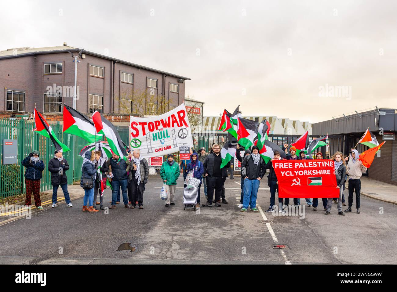 Brough, UK. 02 MAR, 2024. Gathered Pro Palestinian protestors line up outside the gates of the BAE factory in Brough, part of the Humber Enterprise Park, they can be seen holding both Palestine and Communist Party of Great Britain flag and various banners. Story: A protest organised by members of the Young Communist League outside the BAE systems factory in Brough, 12 miles West of Hull. The factory was used in the development of the F-35 aircraft used by Israeli government. Around 33 protestors no arrests. Credit Milo Chandler/Alamy Live News Stock Photo