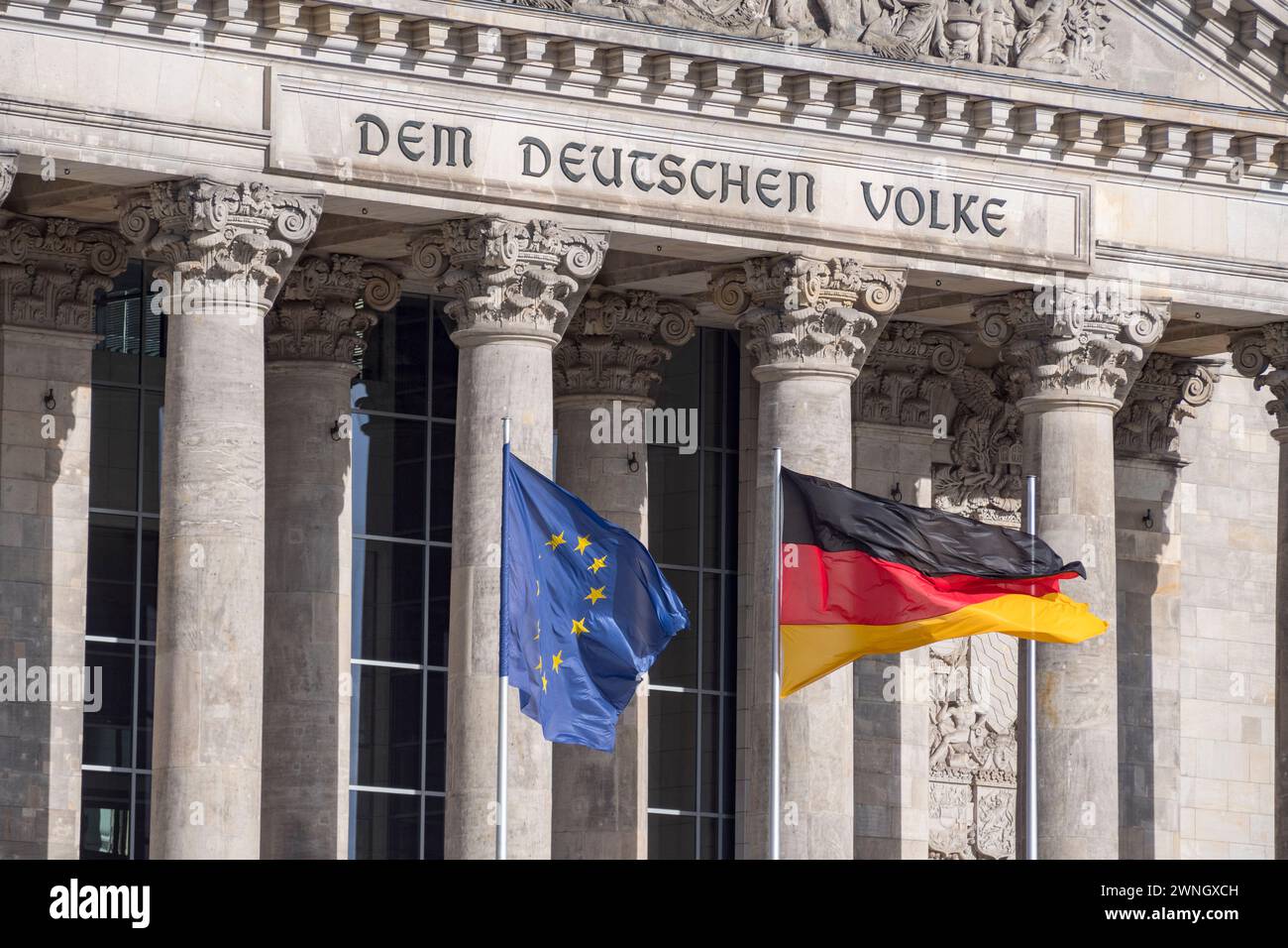EU and German flags flying in front of 'Dem Deutschen Volke' on the Reichstag in Berlin, Germany. Stock Photo