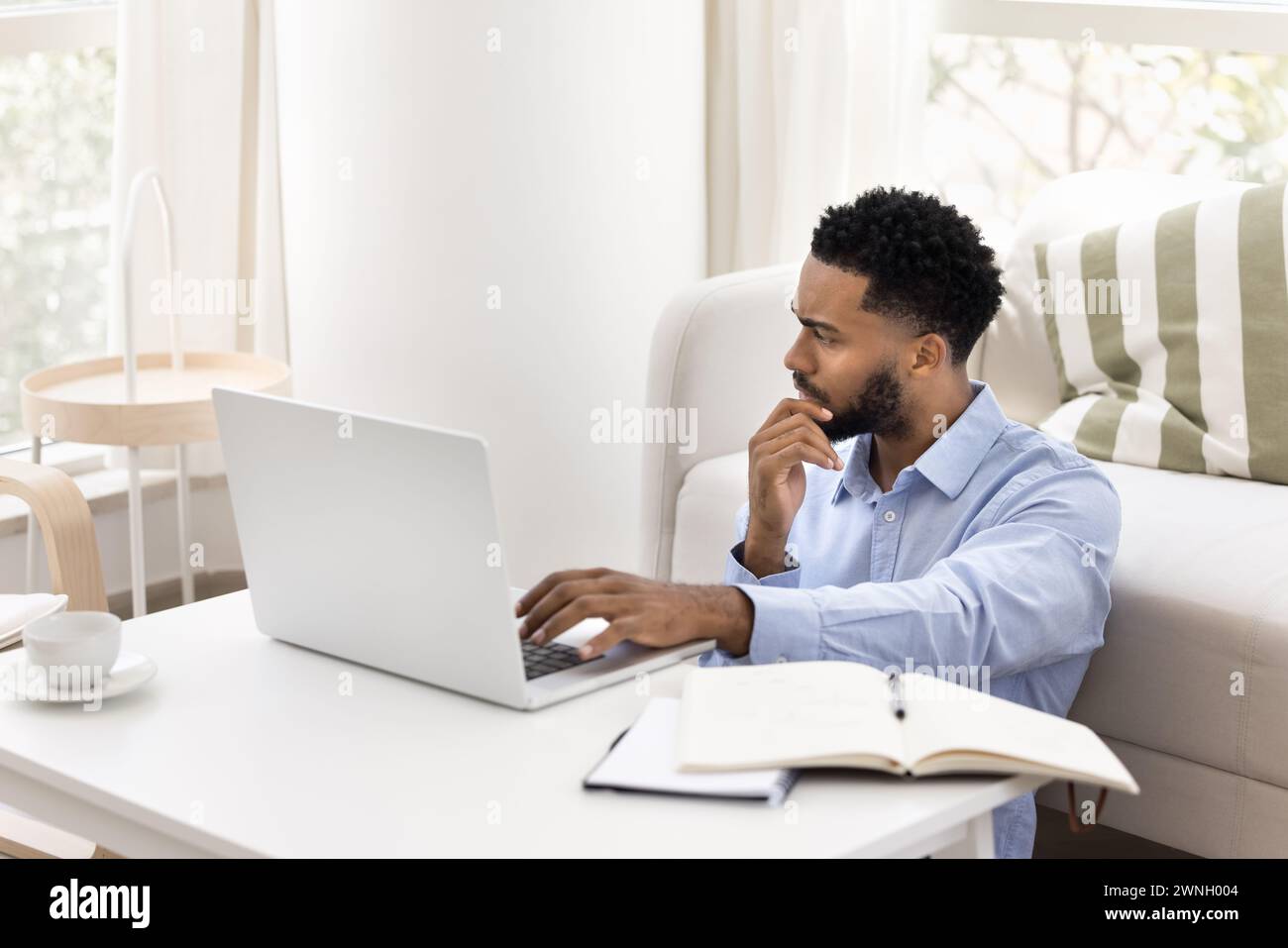 Concerned young African freelancer man thinking on business project Stock Photo