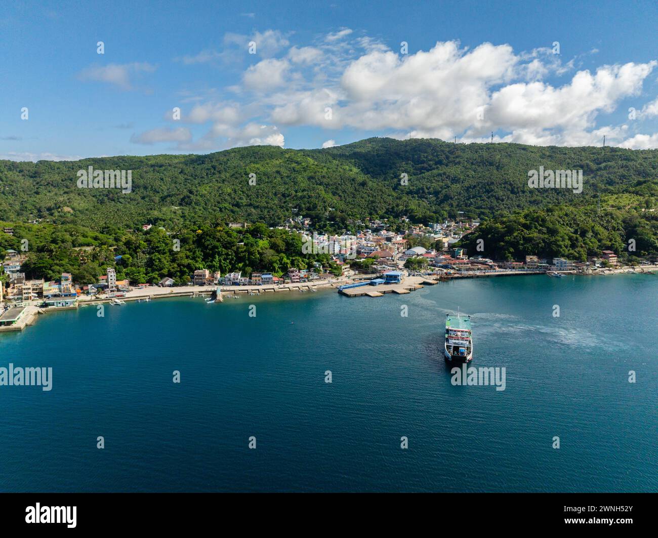 Coastline with port and city with houses. Ferry over the blue sea in Romblon Island. Romblon, Philippines. Stock Photo