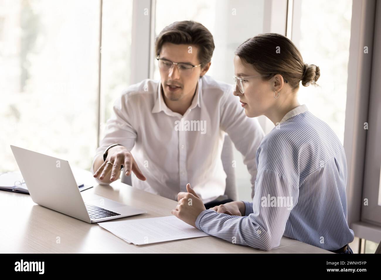 Two workmates talking, working together on joint online project Stock Photo