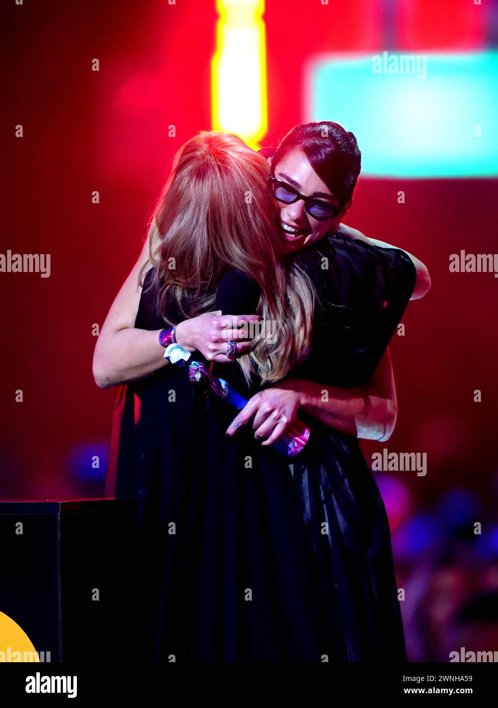Dua Lipa hugs Kylie Minogue on stage as she presents her with the Brits