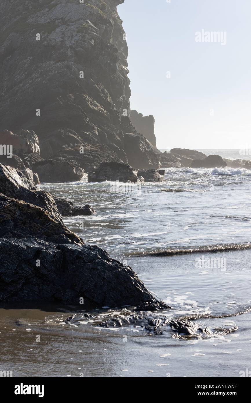 A rocky shoreline with a calm ocean. The rocks are scattered along the ...