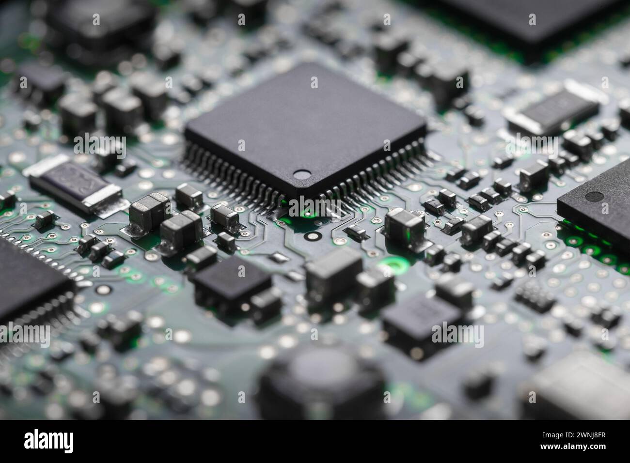 A close-up of a printed circuit board with a processor and various elements in backlight. Stock Photo