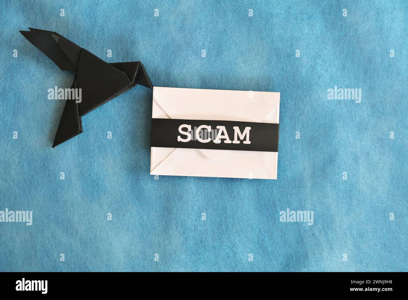 Black raven paper origami carrying white letter envelope with word scam ...