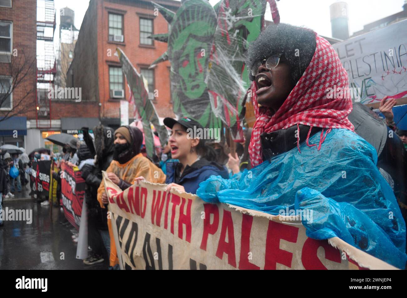 Pro-Palestine demonstrators march, chanting slogans and holding banners expressing their opinion during a rainstorm. Demonstrators rallied in Manhattan, New York City condemning the Israel Defense Forces' military operations in Gaza. Israeli Prime Minister Benjamin Netanyahu and the Israel Defense Forces said their military will soon enter the southern town of Rafah in Gaza. More than half of Gaza's 2.3 million population are sheltered in Rafah living in tents and United Nations' shelters. Israel's war cabinet is reviewing a plan to evacuate people from Rafah before Israeli troops enter the ci Stock Photo