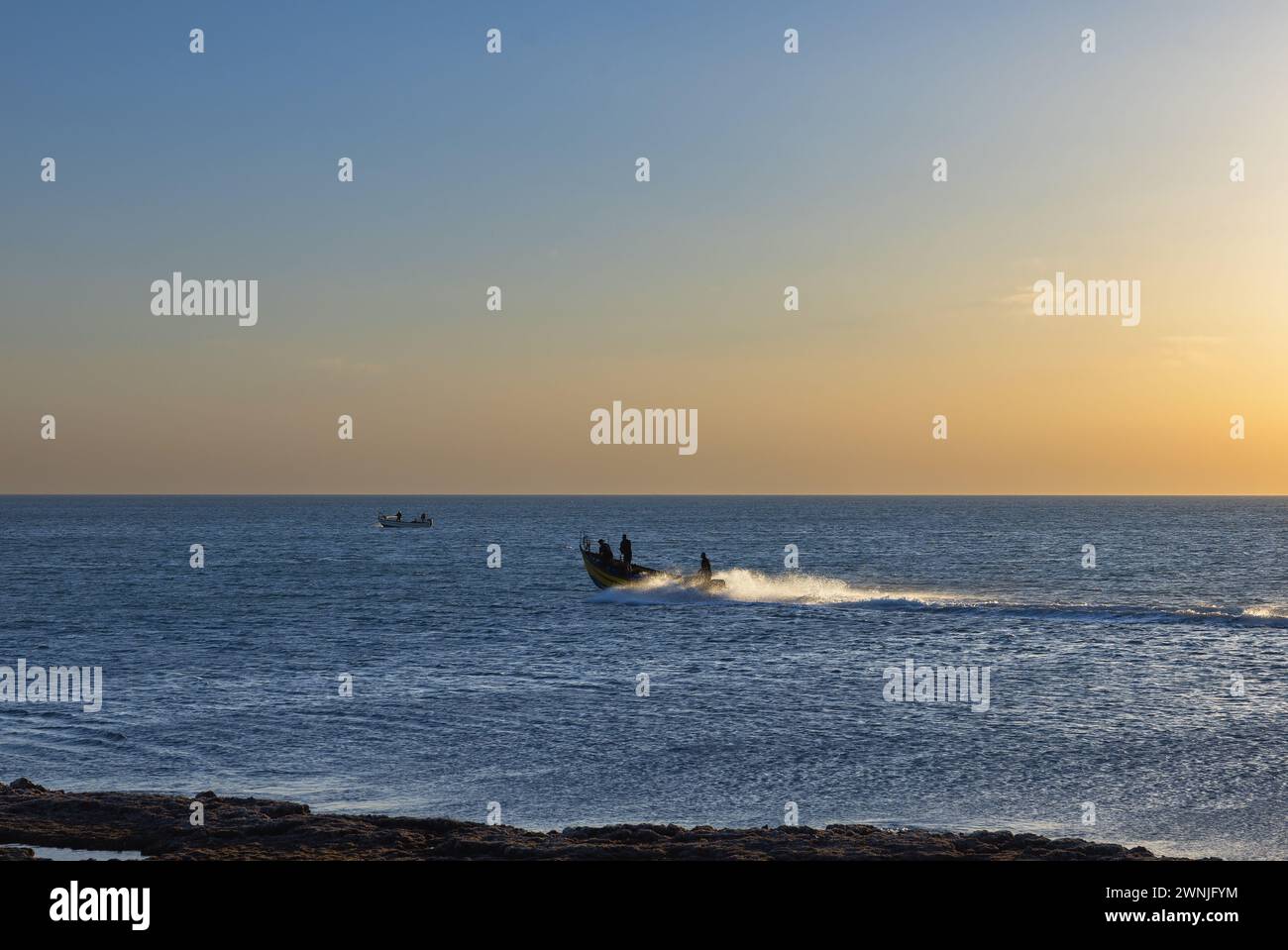 Fishermen on boats in the Mediterranean sea at sunset Israel Stock Photo