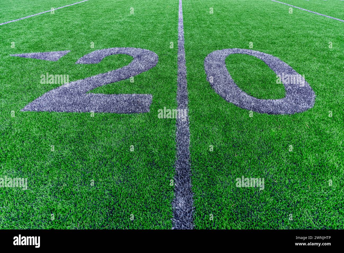 Synthetic turf football 20 yard line and block style numbers in gray.  Practice football turf markings are less obvious and installed in the outfield Stock Photo