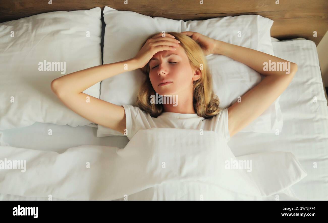 Upset exhausted woman with headache, pain tension in the head, suffers from migraine lying on