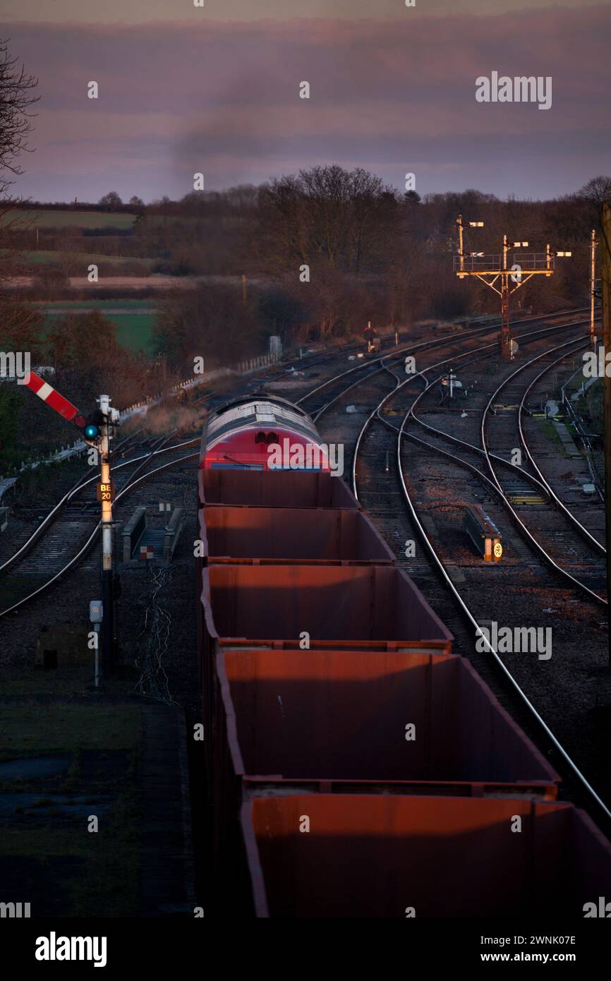 Freight train carrying Iron Ore passing The mechanical semaphore signals at Barnetby east, Lincolnshire, UK Stock Photo