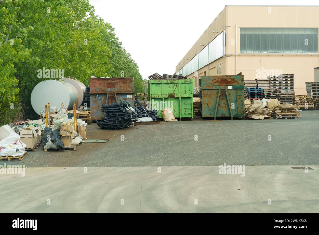 A significant amount of trash piled up in front of a building, creating a sight of environmental degradation and neglect. Stock Photo