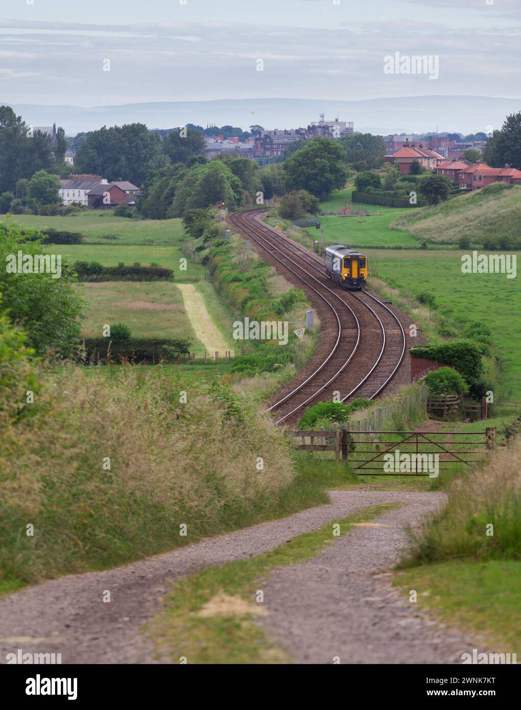 A Northern rail class 156 sprinter train passes Cummersdale on the Cumbrian coast line  with a  Barrow In Furness - Carlisle service Stock Photo