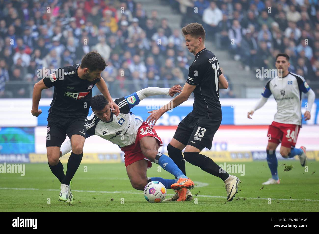 Hamburg, Germany. 03rd Mar, 2024. Soccer: Bundesliga 2, matchday 24, Hamburger SV - VfL Osnabrück, at the Volksparkstadion. Hamburg's Ransford Königsdörffer (M) and Osnabrück's Bashkim Ajdini (l) and Lukas Kunze fighting for the ball. Credit: Christian Charisius/dpa - IMPORTANT NOTE: In accordance with the regulations of the DFL German Football League and the DFB German Football Association, it is prohibited to utilize or have utilized photographs taken in the stadium and/or of the match in the form of sequential images and/or video-like photo series./dpa/Alamy Live News Stock Photo