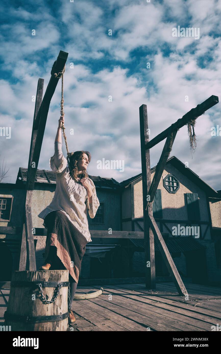A place for the execution of criminals by hanging in a vintage city of medieval Europe and a woman standing at the gallows Stock Photo