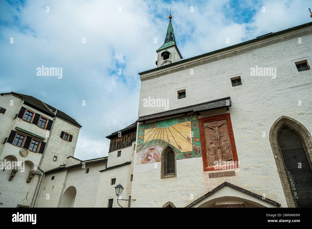 The facade of a historic castle with a sundial and a green roof, Salzburg, Austria Stock Photo