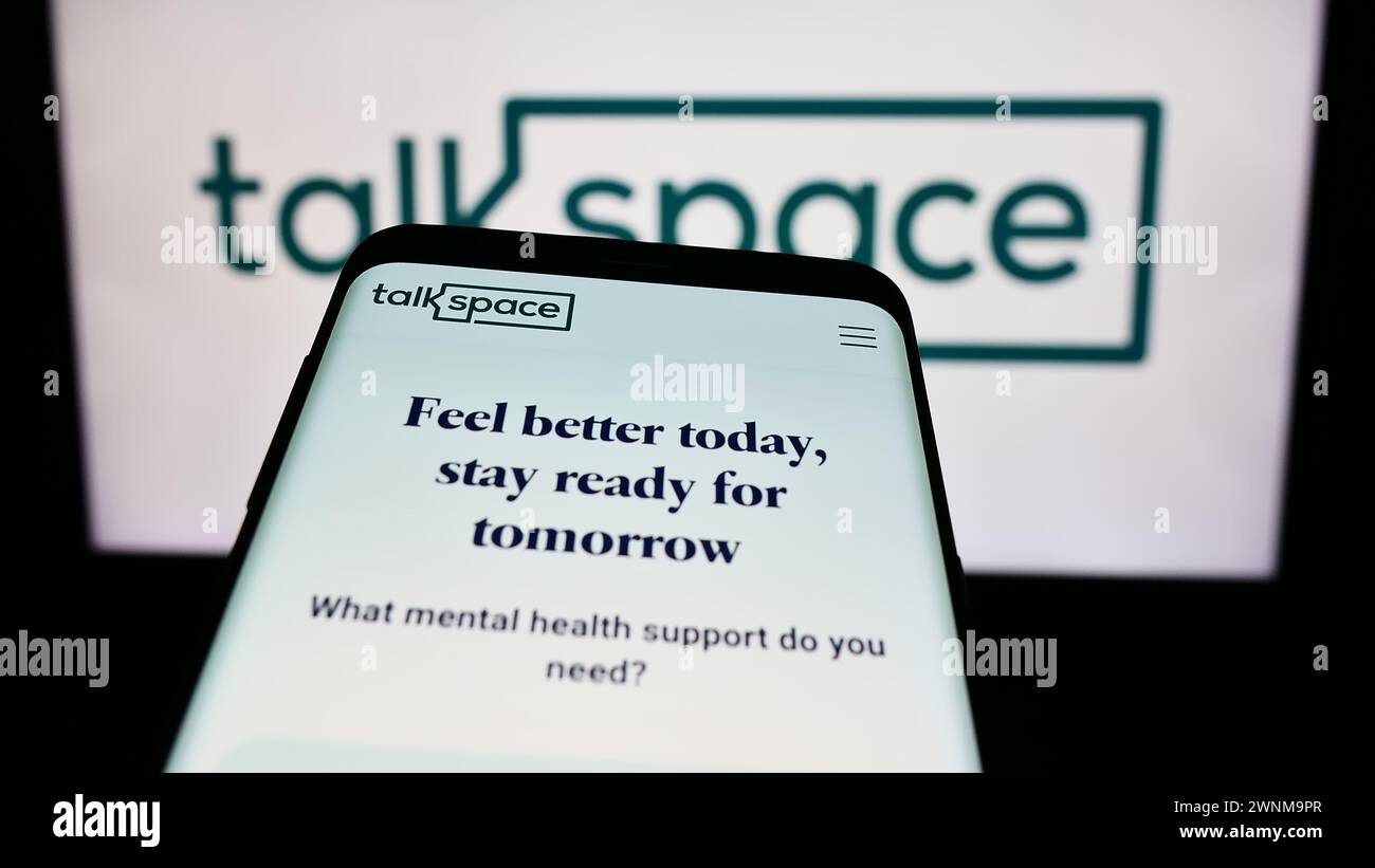 Mobile phone with website of US online psychotherapy company Talkspace Inc. in front of business logo. Focus on top-left of phone display. Stock Photo