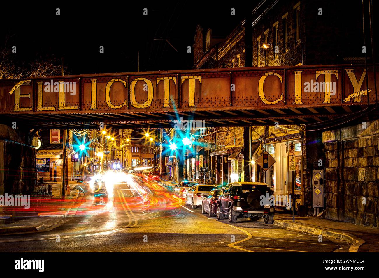 Ellicott City, Maryland at night, with cars driving under a bridge. Stock Photo