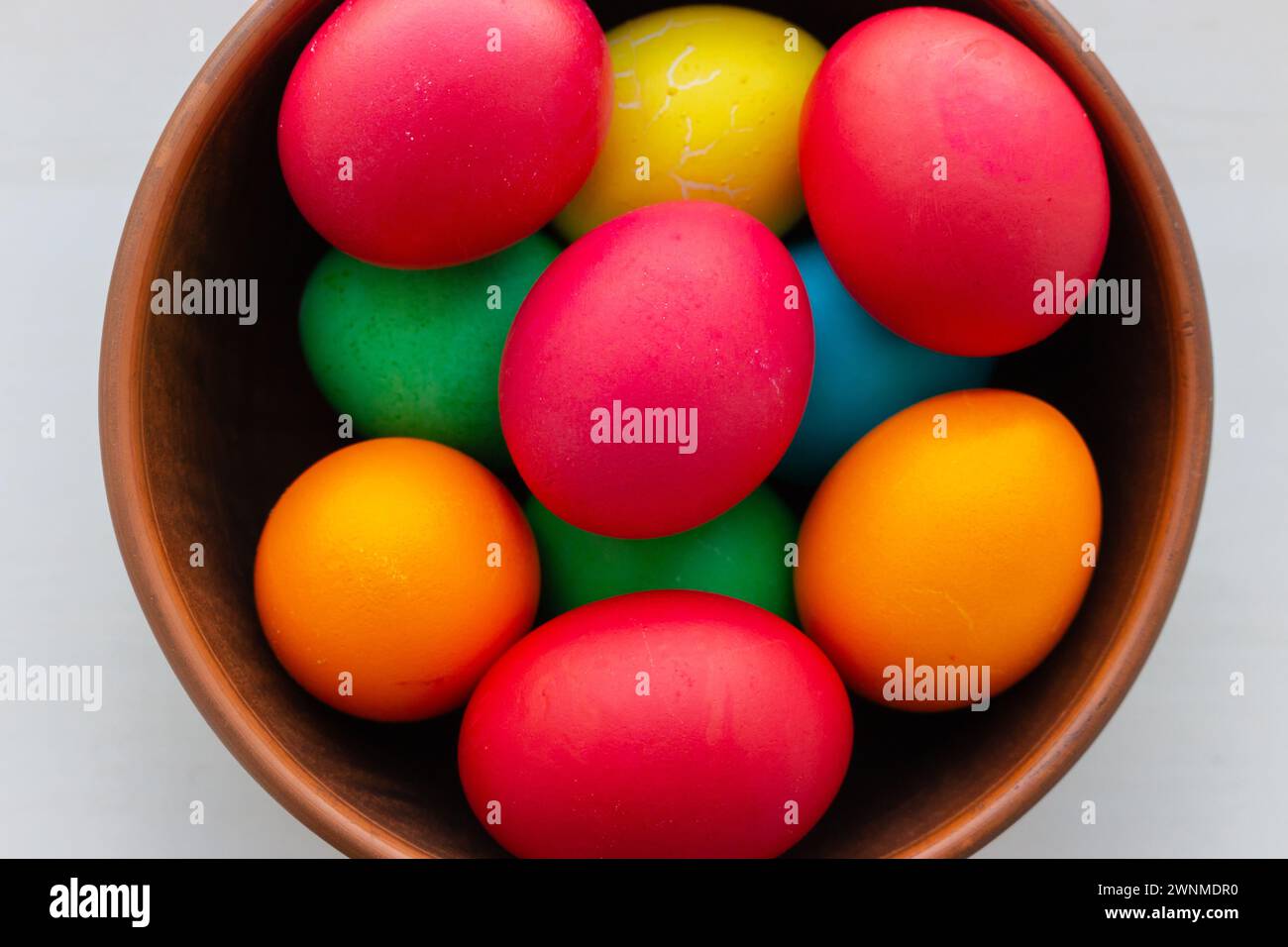 Easter eggs in brown bowl. Happy Easter holiday. Colourful painted eggs. Bright boiled eggs. Easter traditional decoration. Christian holiday. Stock Photo