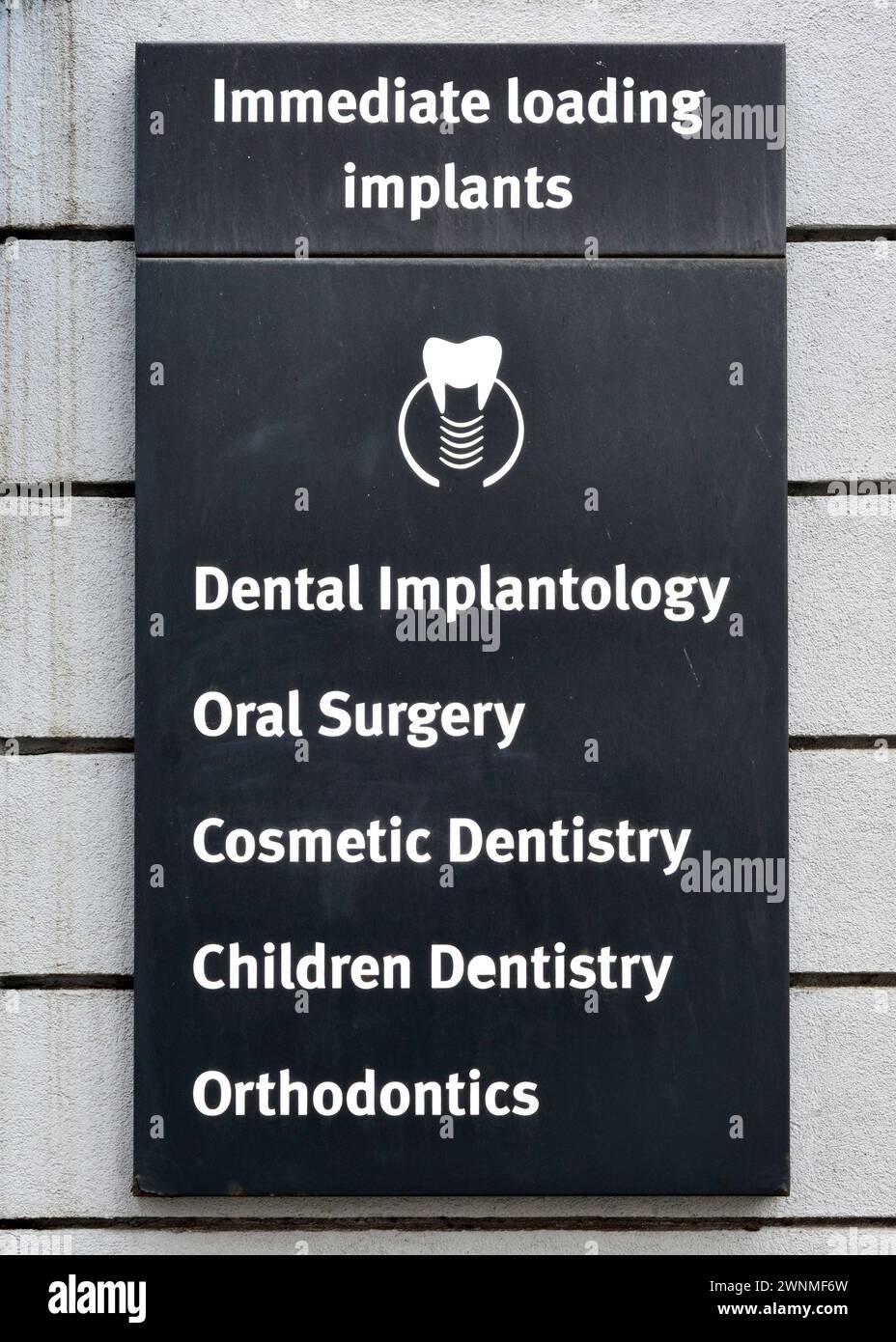 Immediate loading implants, dental implantology, oral surgery, cosmetic dentistry, children dentistry, orthodontics sign at dental services practice Stock Photo