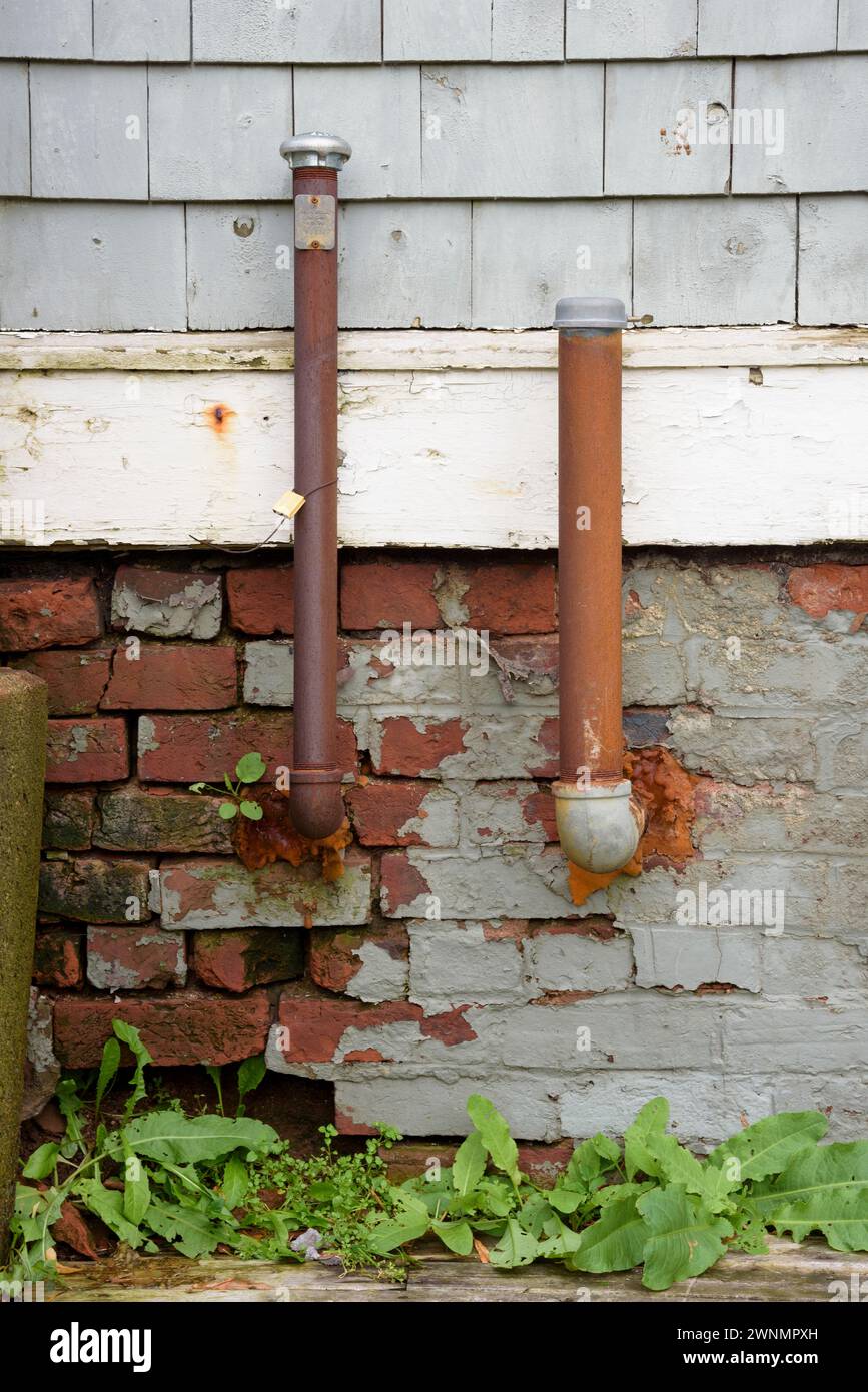 Rusty oil and vent pipes used to pump heating oil in the tank of a domestic furnace. Stock Photo