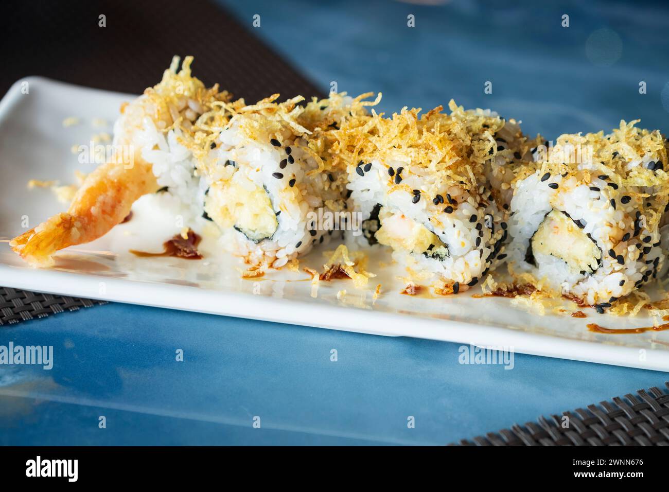 Close up of unagi ebi ten roll,view.sushi set with shrimp in tempura, oshinko, garnished with edible flower and black sesame, on an oriental tray, pla Stock Photo