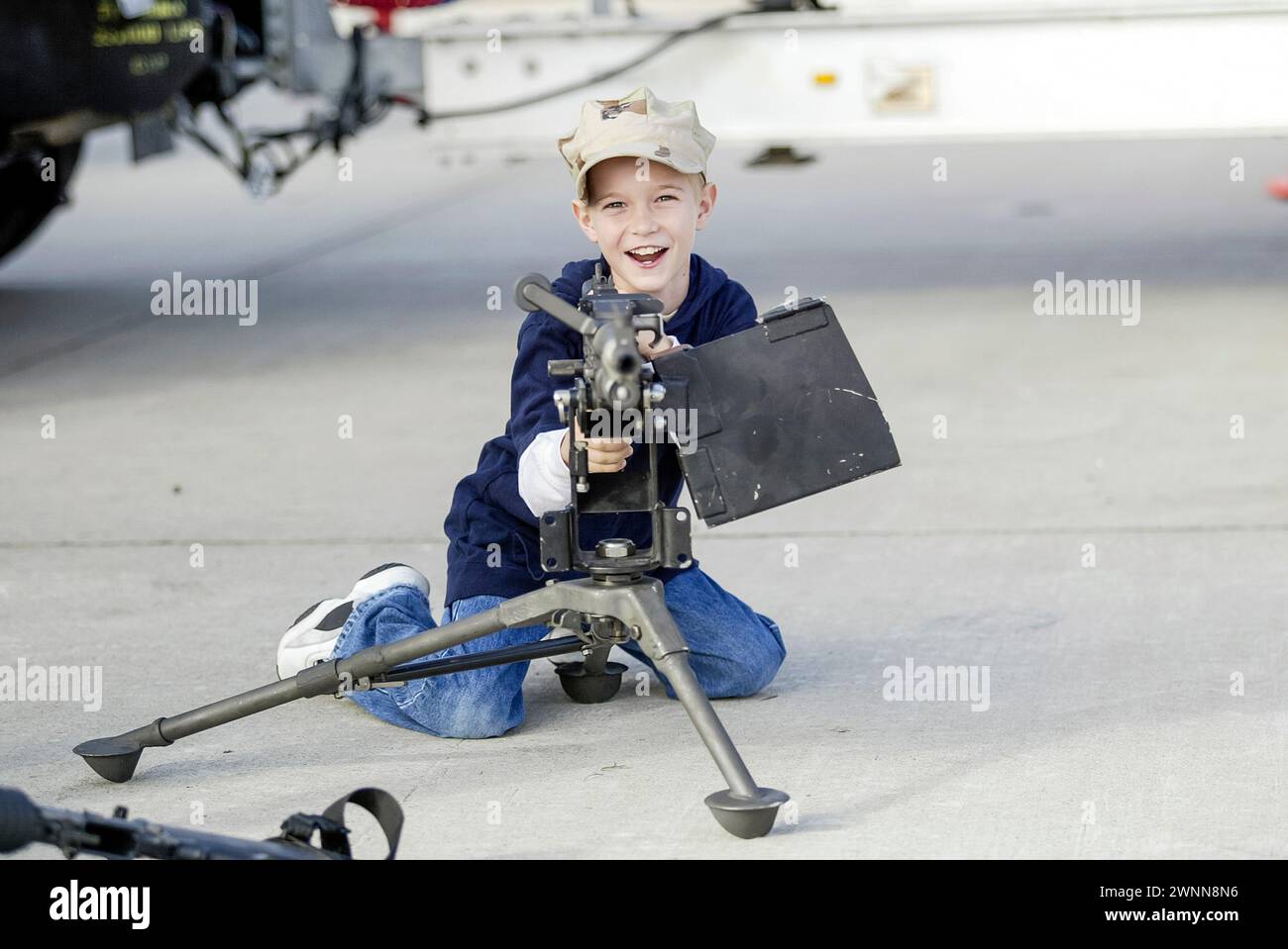 A young boy checks out the machine guns on display at the Miramar Air Show in San Diego, CA. Stock Photo