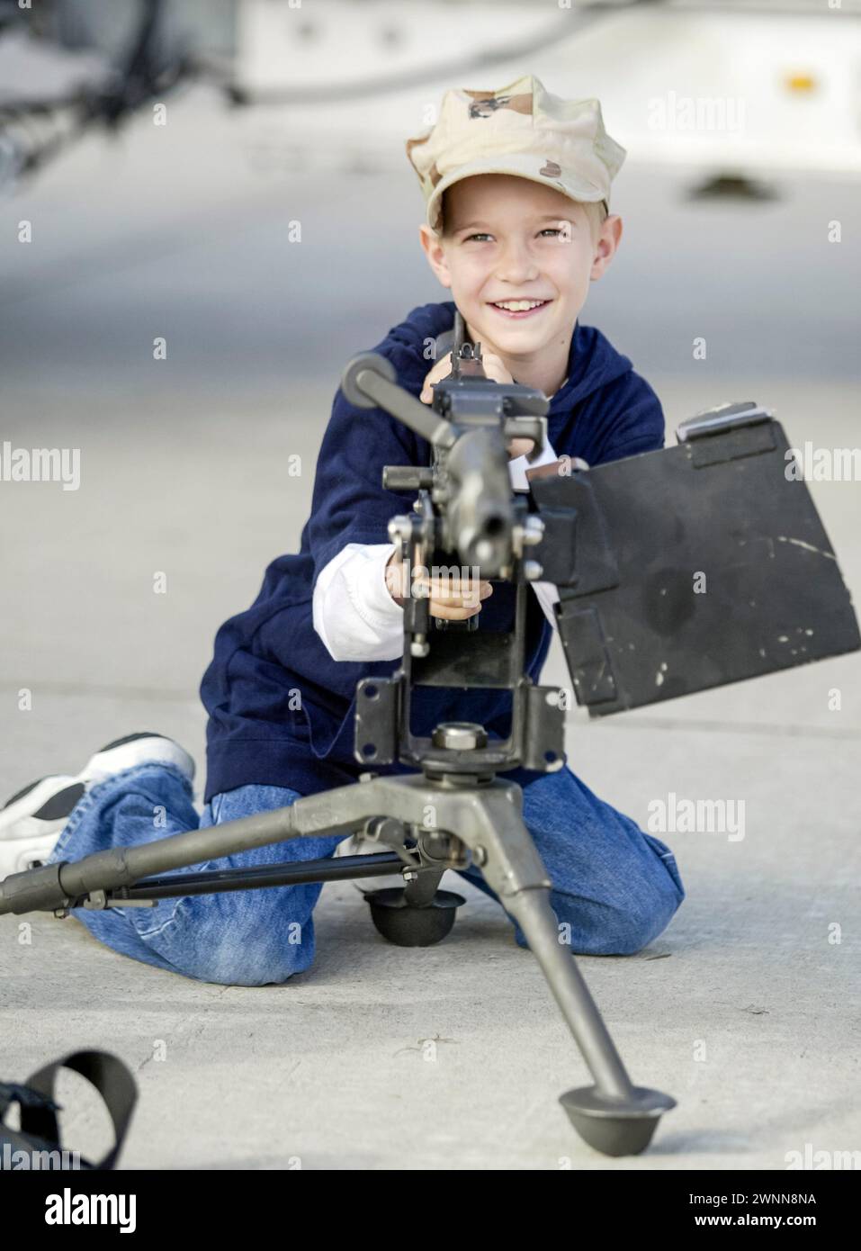 A young boy checks out the machine guns on display at the Miramar Air Show in San Diego, CA. Stock Photo