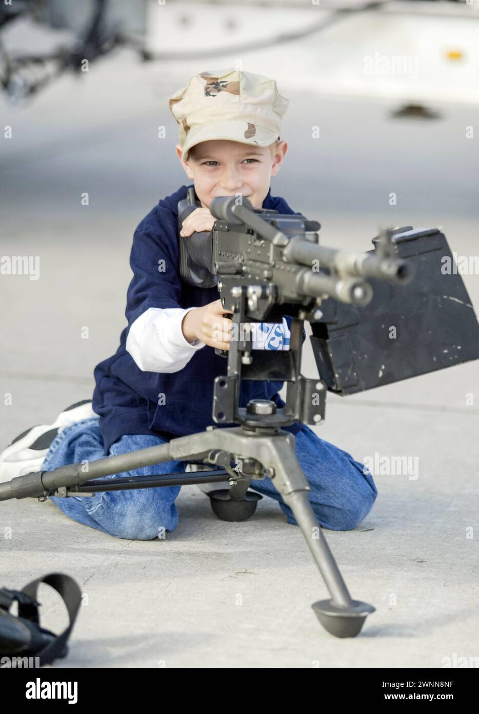 A young boy checks out the machine guns on display at the Miramar Air Show in San Diego, CA. Stock Photo