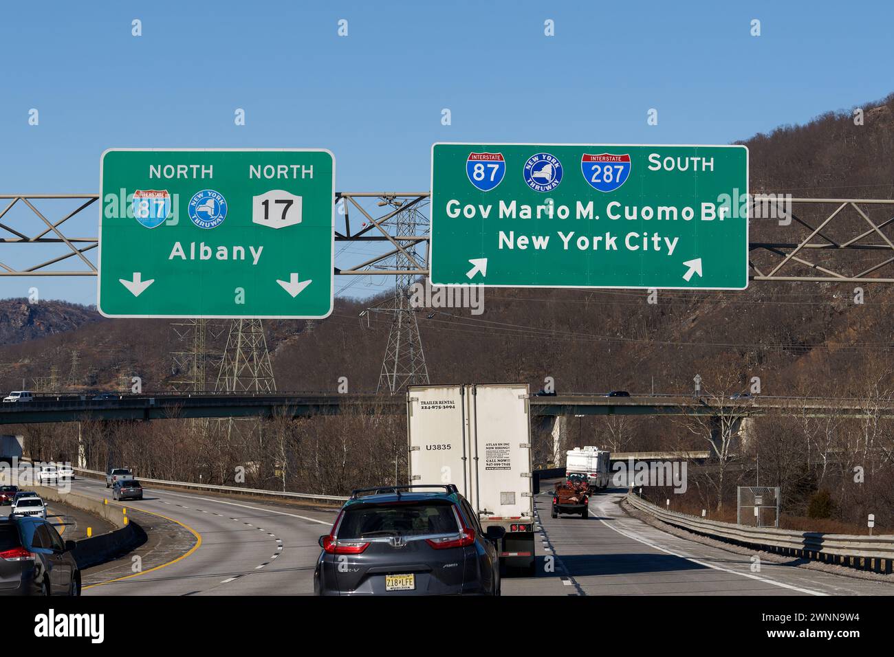 Suffern, NY - Feb 27, 2022: Exit signs on I-287 for I-87 New York State Thruway North toward Albany and NY-17, and South toward Governor Mario M. Cuom Stock Photo