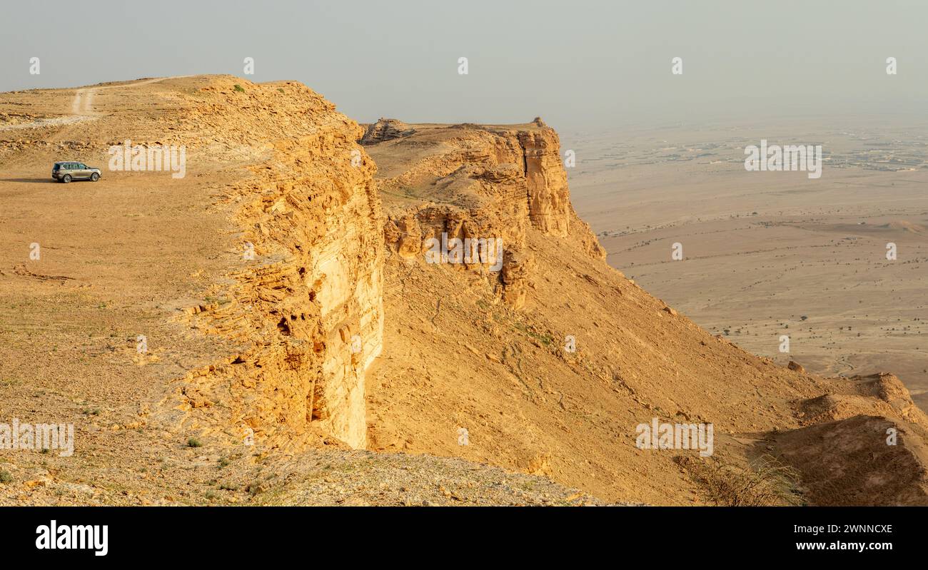 Car on the edge of the Jabal Tuwaiq Mountains, with desert landscape, Riyadh, Saudi Arabia Stock Photo