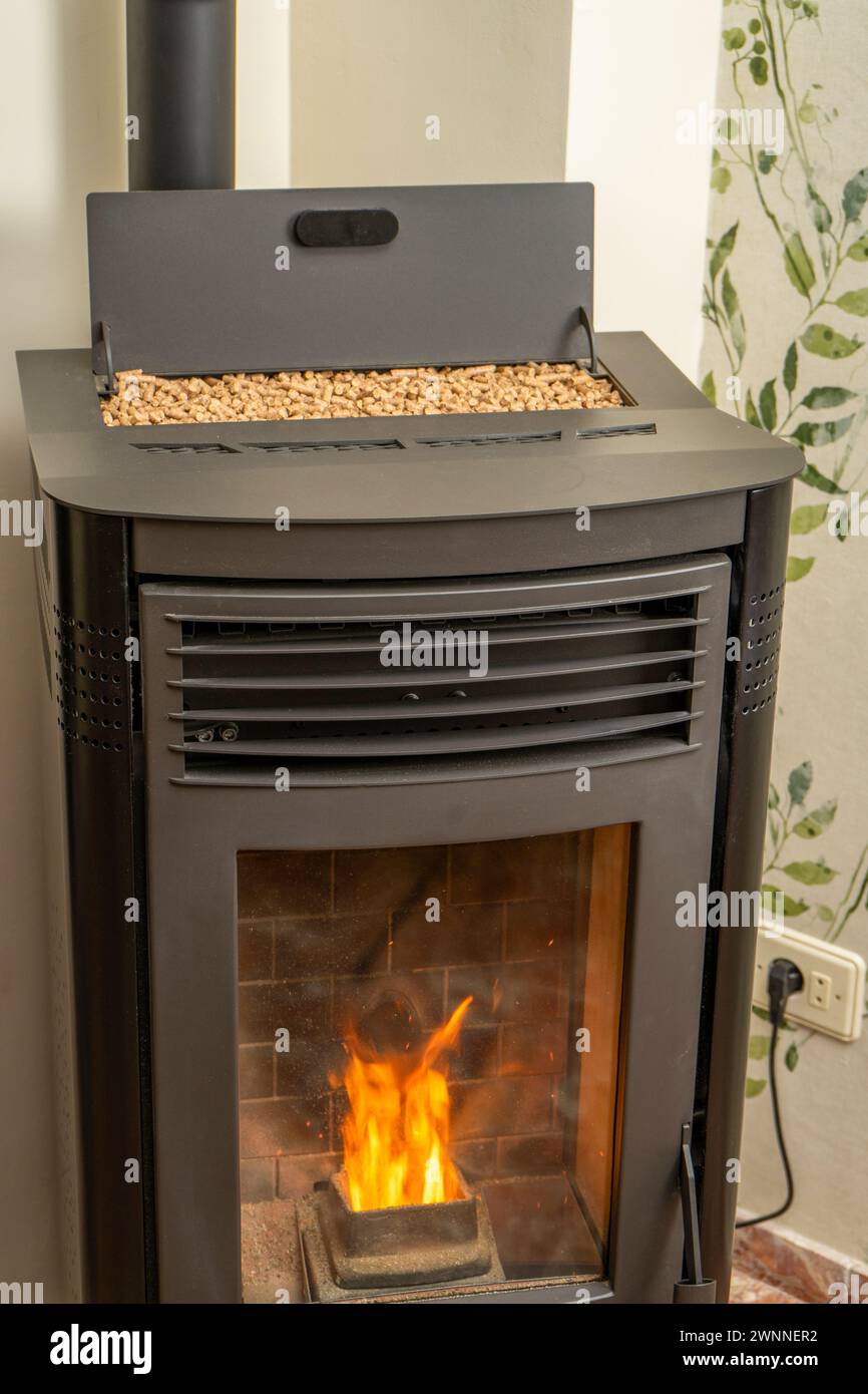 Vertical image of a modern pellet stove with the hopper full to