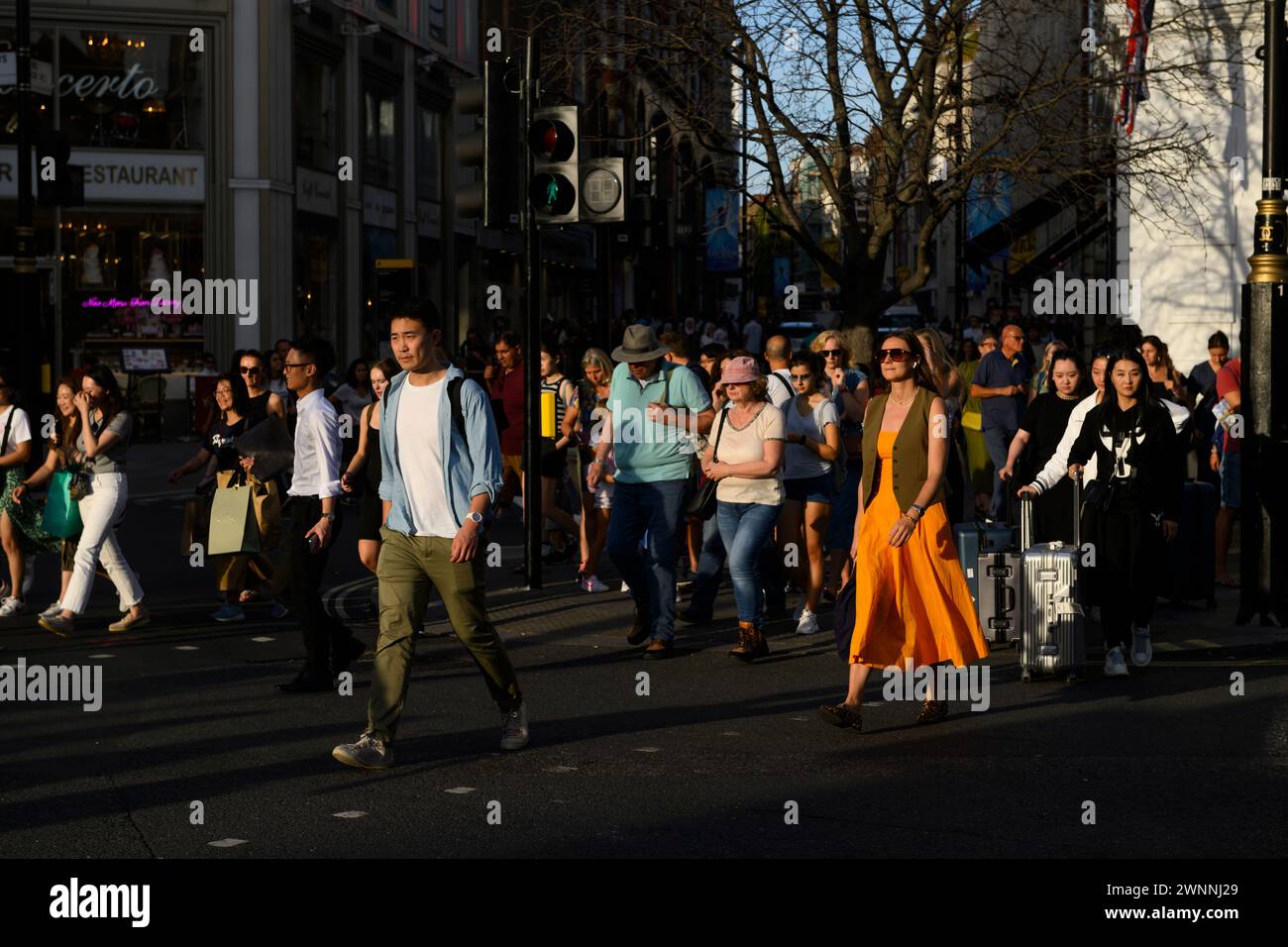 Pedestrians crossing the road at the junction of  Long Arce and Great Newport Street, London, UK.  23 Aug 2023 Stock Photo