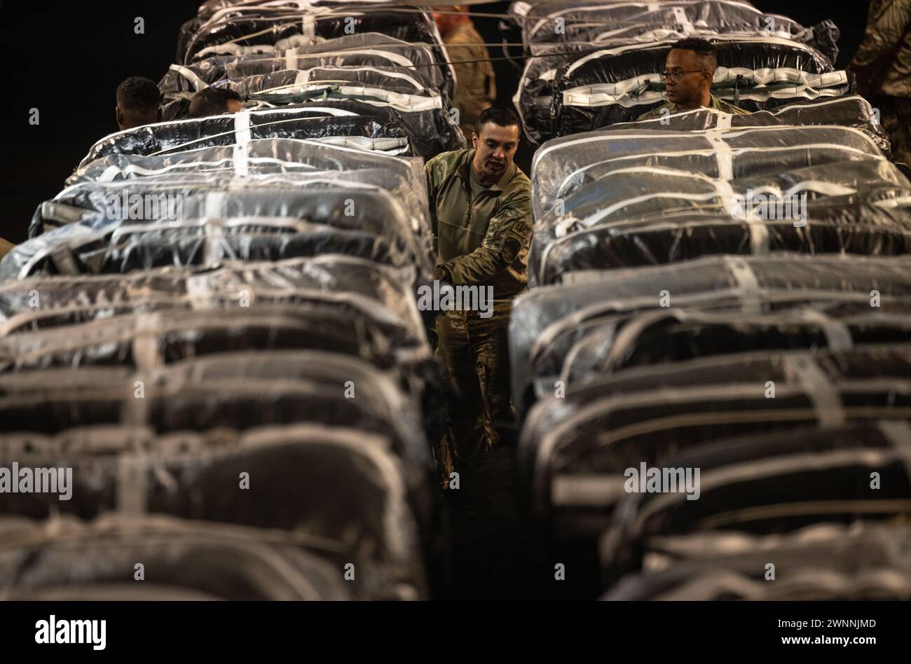 Azraq, Jordan. 01st Mar, 2024. A U.S. Army soldier secures straps on humanitarian aid pallets in the cargo bay of a U.S. Air Force C-130J Super Hercules aircraft at Muwaffaq Salti Air Base, March 1, 2024 in Azraq, Zarqa Governorate, Jordan. The food aid will be airdropped to Palestinian refugees trapped by the Israeli war against Hamas. Credit: TSgt. Christopher Hubenthal/US Airforce Photo/Alamy Live News Stock Photo