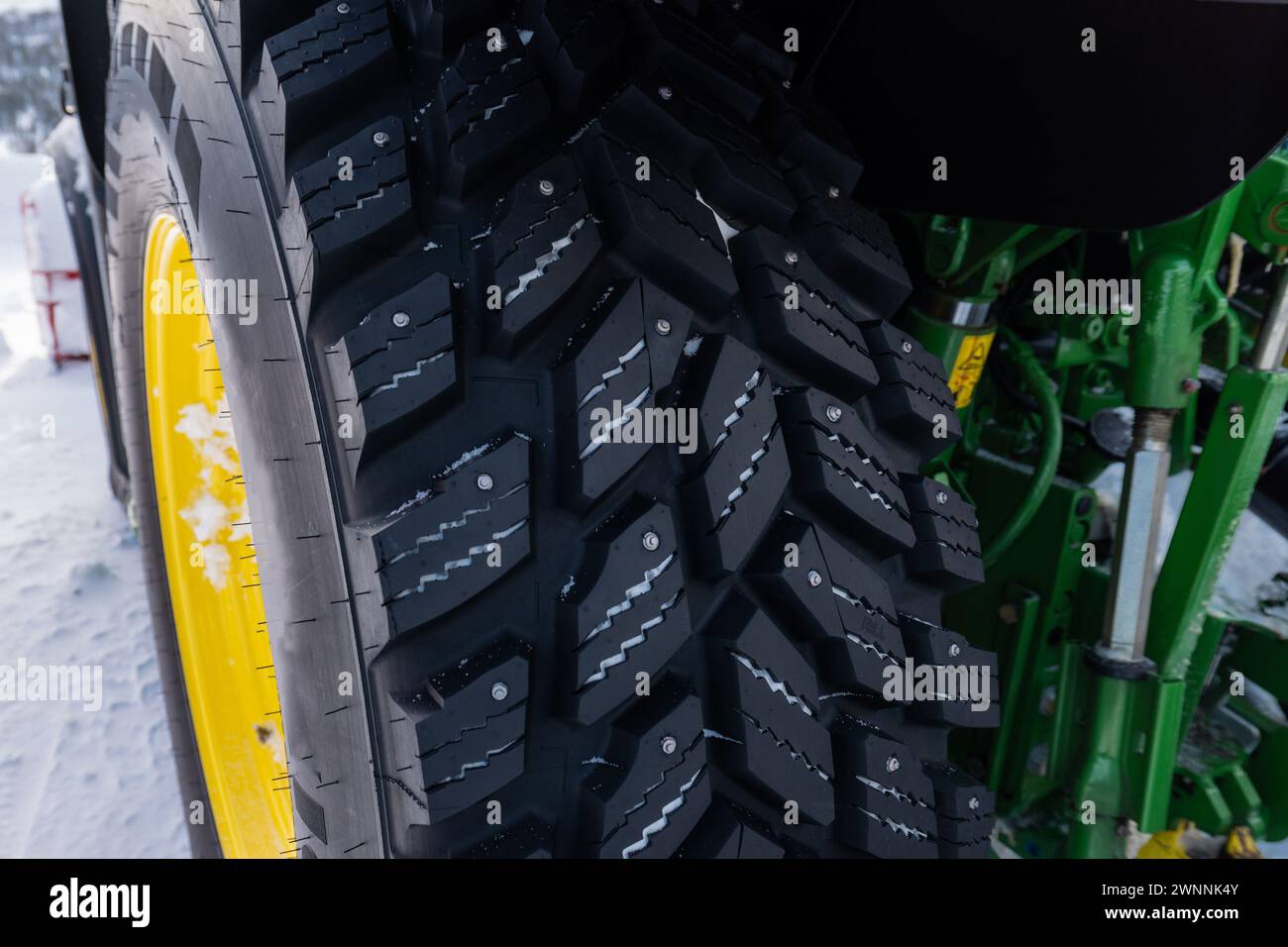 Tractor tire or tyre with deep profile and metal studs for safe winter driving on icy roads. Stock Photo