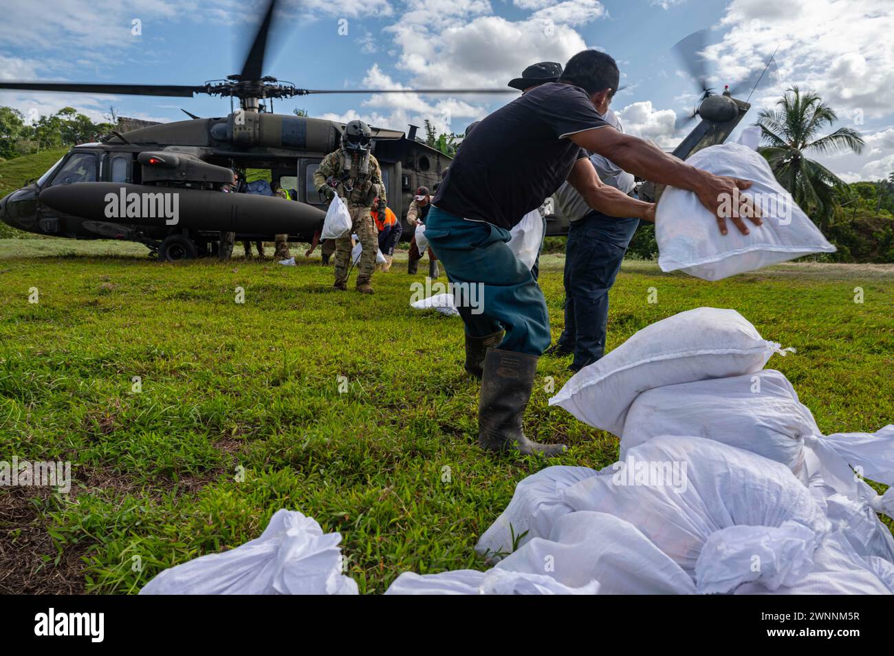 Rambala, Panama. 29 February, 2024. U.S. Army soldier and Panama civilians unload food and structural materials from a UH-60 Blackhawk helicopter during Exercise PANAMAX, February 29, 2024 near Rambala, Panama, Feb. 29, 2024. During the exercise the 1-228th Aviation Regiment transported over 500 thousand pounds of equipment including food and supplies as well as medical team to care for local residents.  Credit: TSgt. Nick Erwin/US Army/Alamy Live News Stock Photo