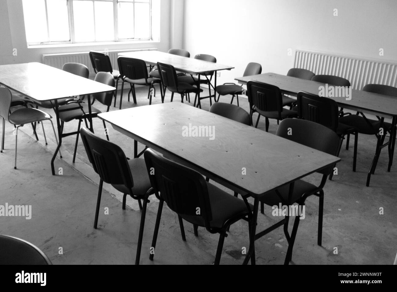 Empty Desolote Classroom With Empty Desk and Seats Stock Photo