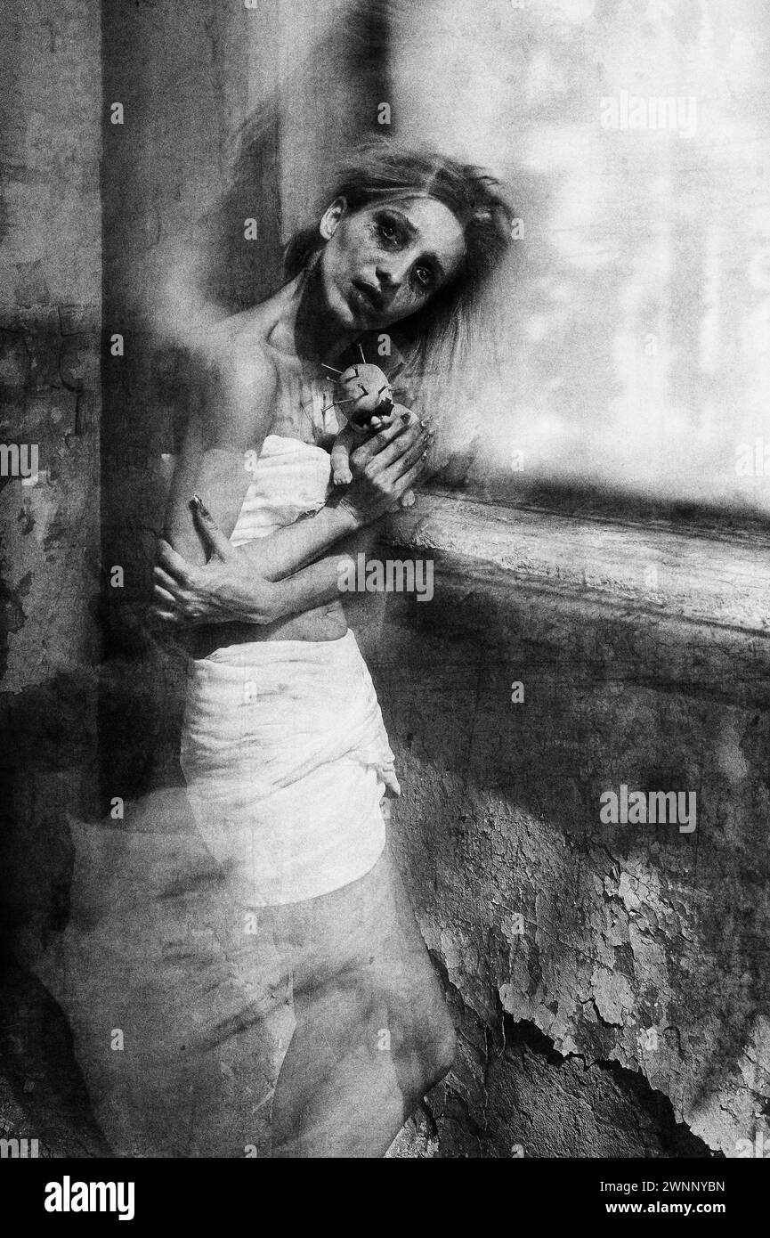 Strange mad girl with creepy ugly doll in abandoned place (asylum). Crazy morbid young woman (freak). Portrait of the mental sick (madman). Black and Stock Photo