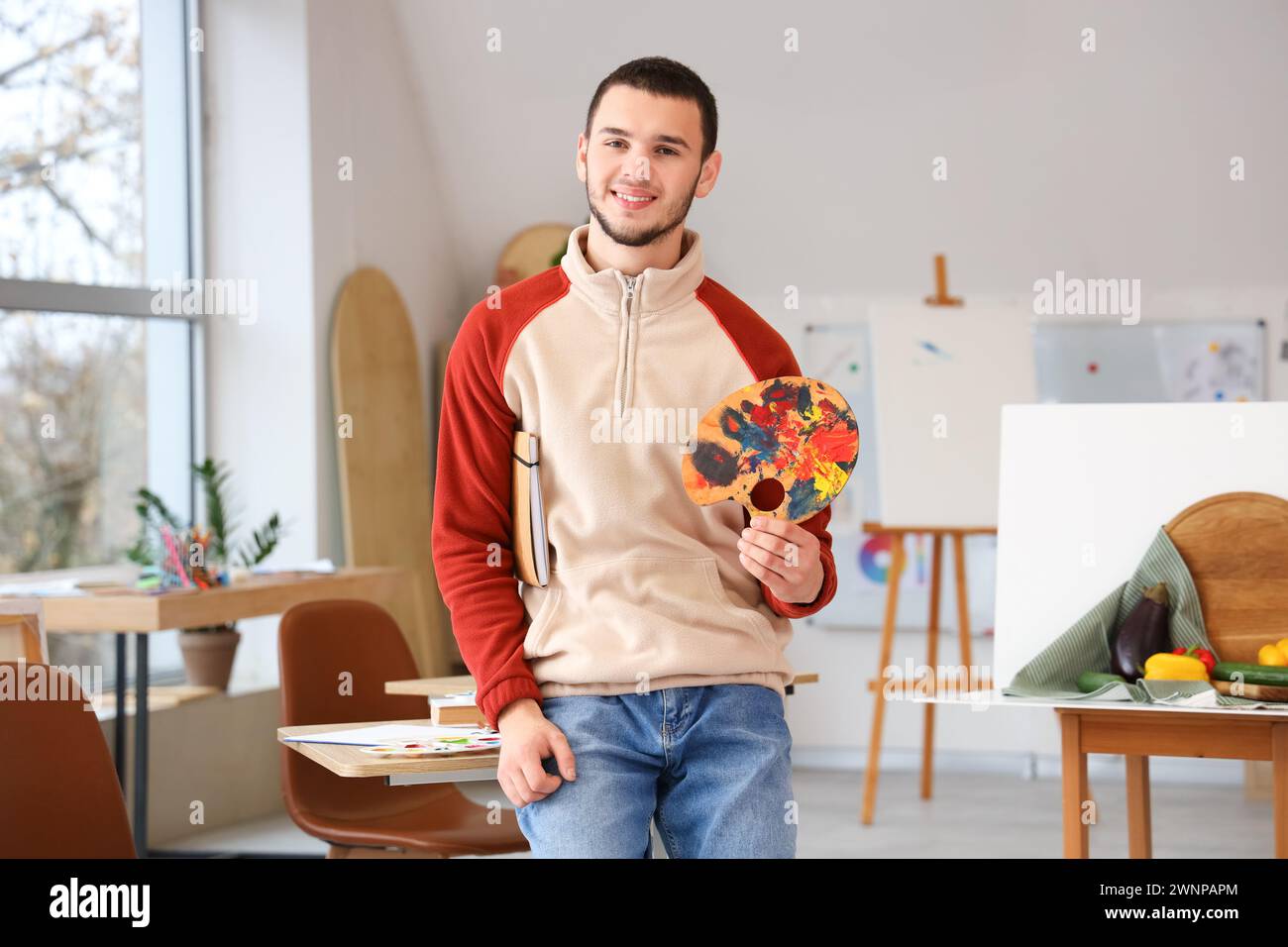 Male student with paint palette in art school Stock Photo - Alamy