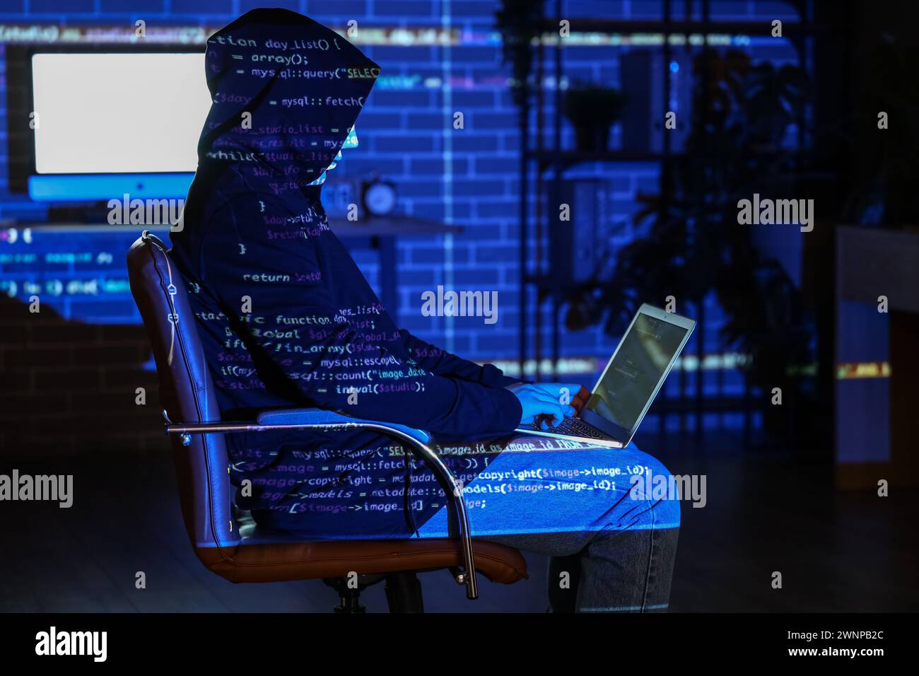 Hacker using laptop and projection of programming code in dark room Stock Photo