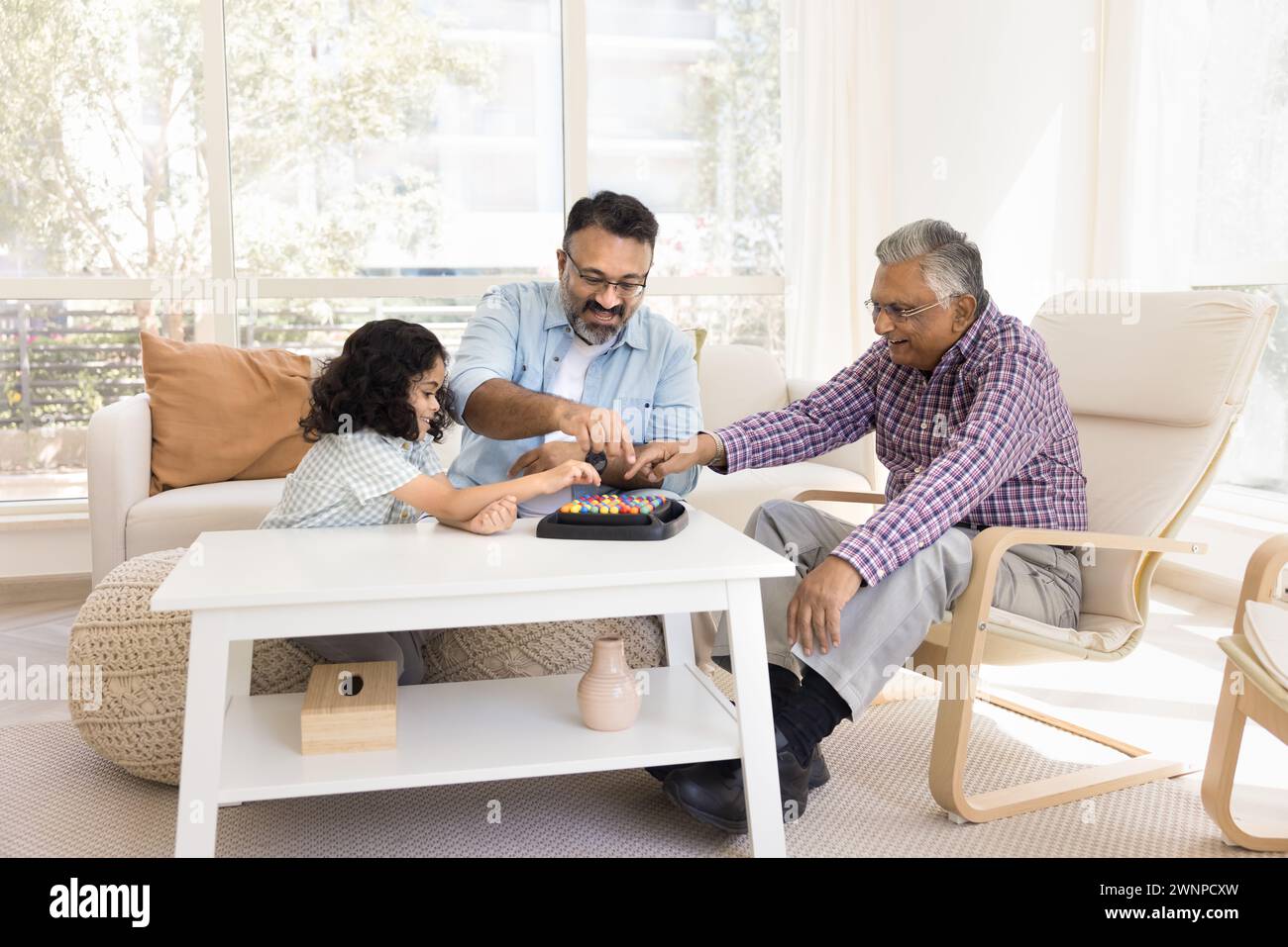 Cheerful Indian senior grandads and little granddaughter playing with balls Stock Photo