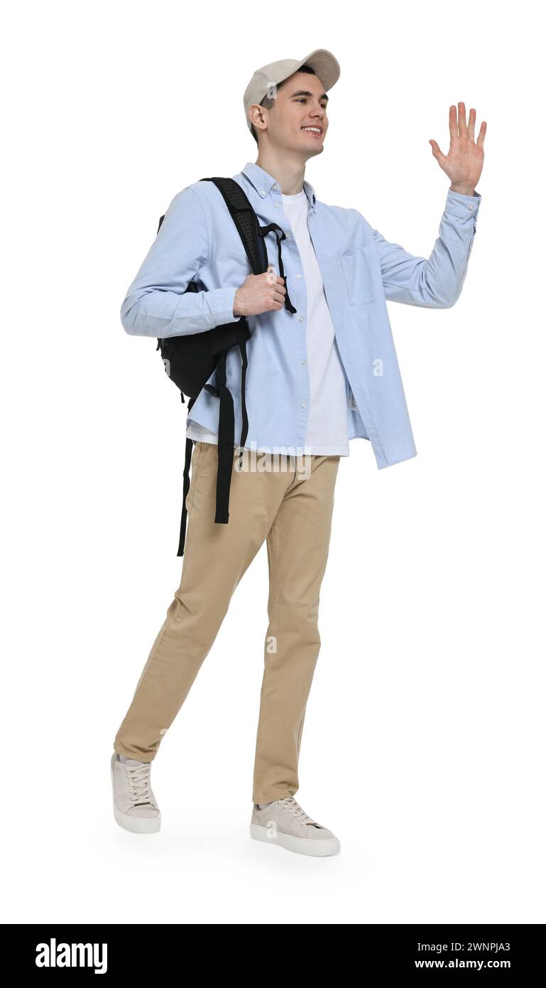 Young man with cap and backpack waving hand on white background Stock ...