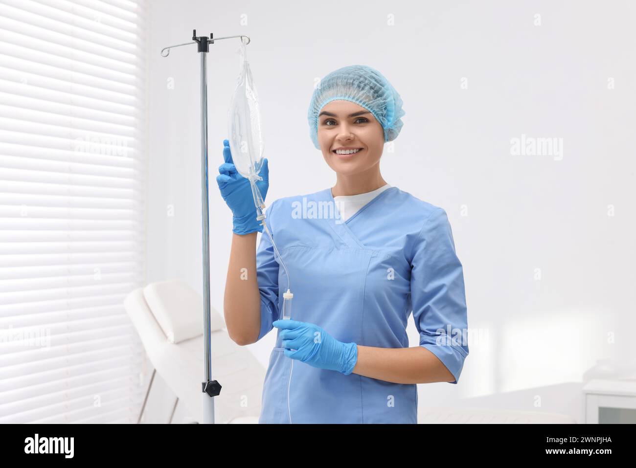 Nurse setting up IV drip in hospital Stock Photo