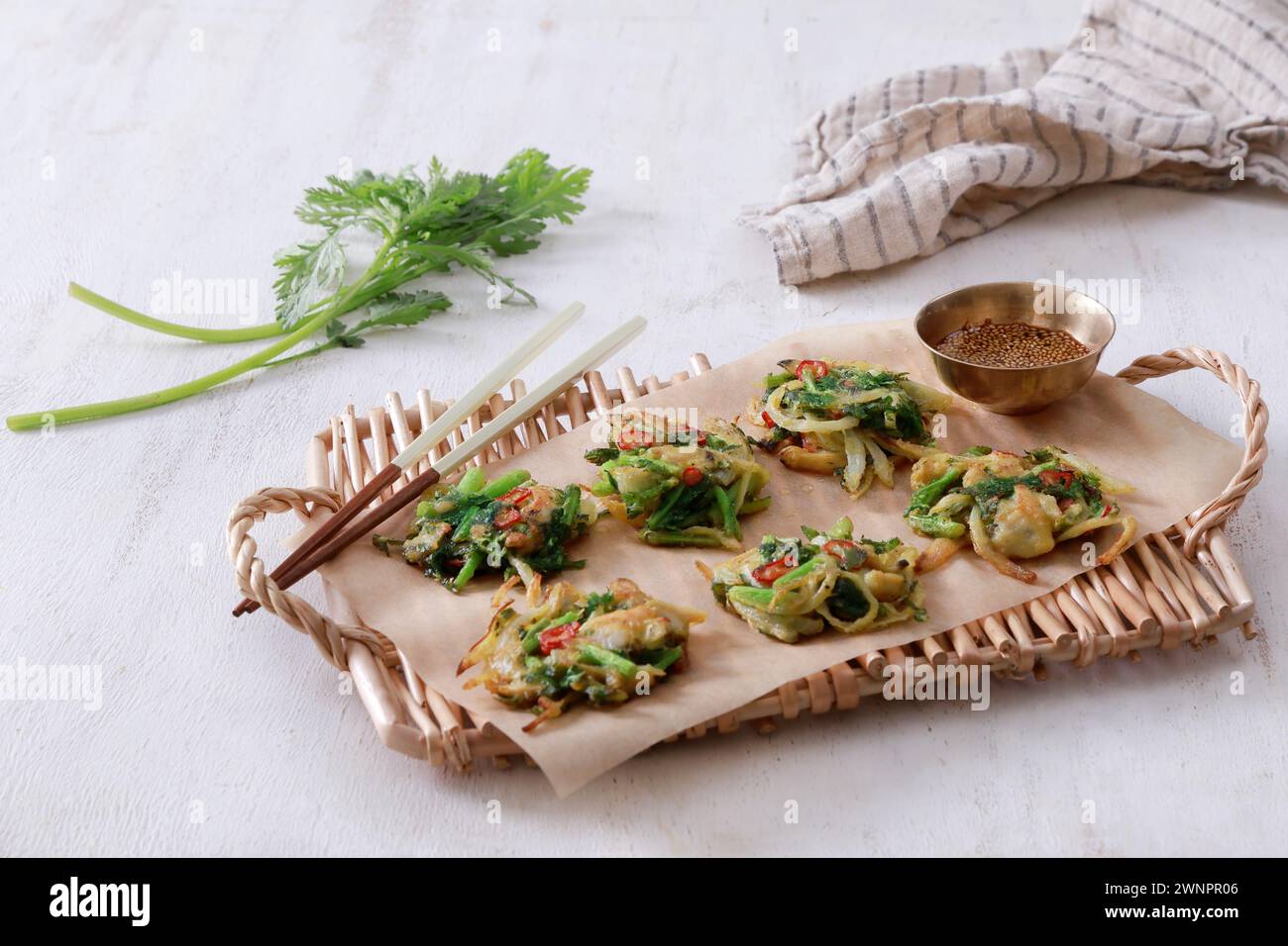 This is a delicious and savory Korean mugwort pancake (쑥갓전). The pancake is crispy on the outside and soft and fluffy on the inside. Stock Photo