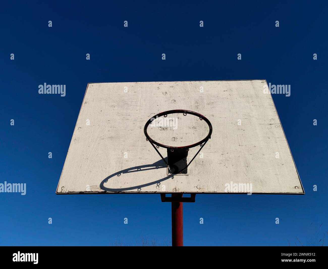 Sky bound swishes. Black rim and white board basketball time under blue sky. Stock Photo