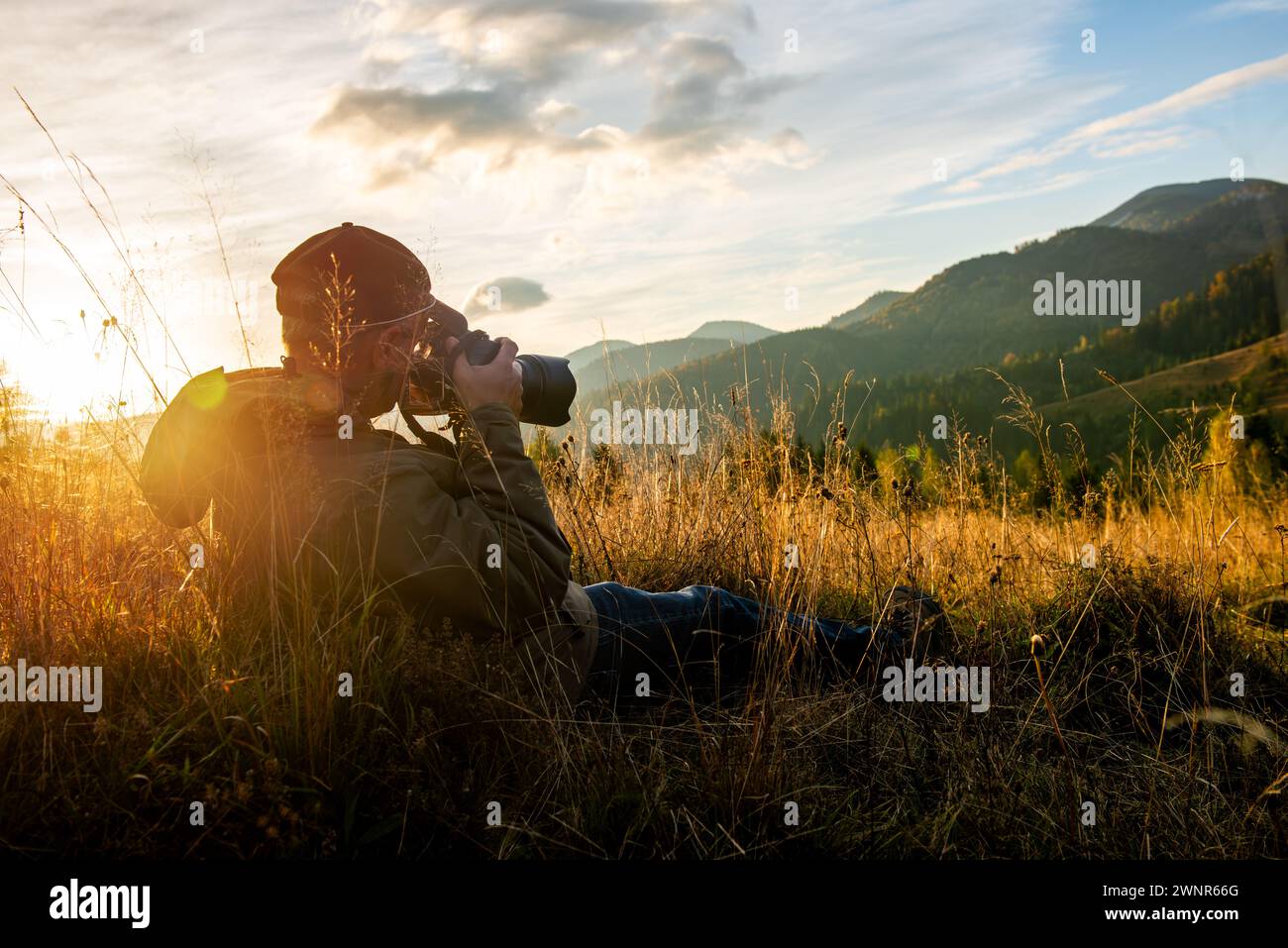 Professional nature photographer in mountain with sunset. Photography Concept Stock Photo