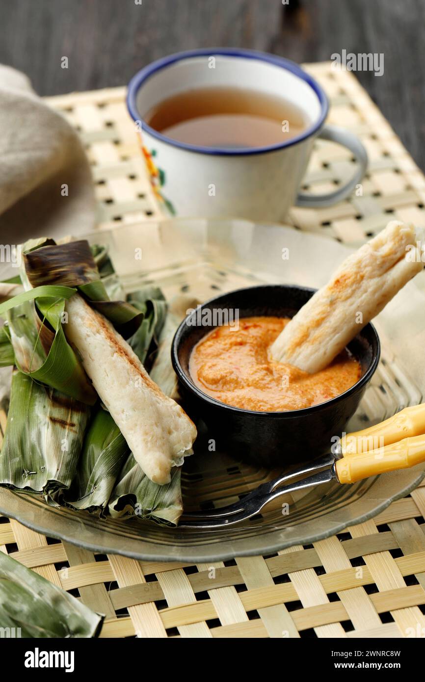 Otak-Otak Bakar  is a Traditional Indonesian Fish Cake Made From Minced Fish Wrapped in Banana Leaf, Grilled, and Served with Peanut Sauce. Stock Photo