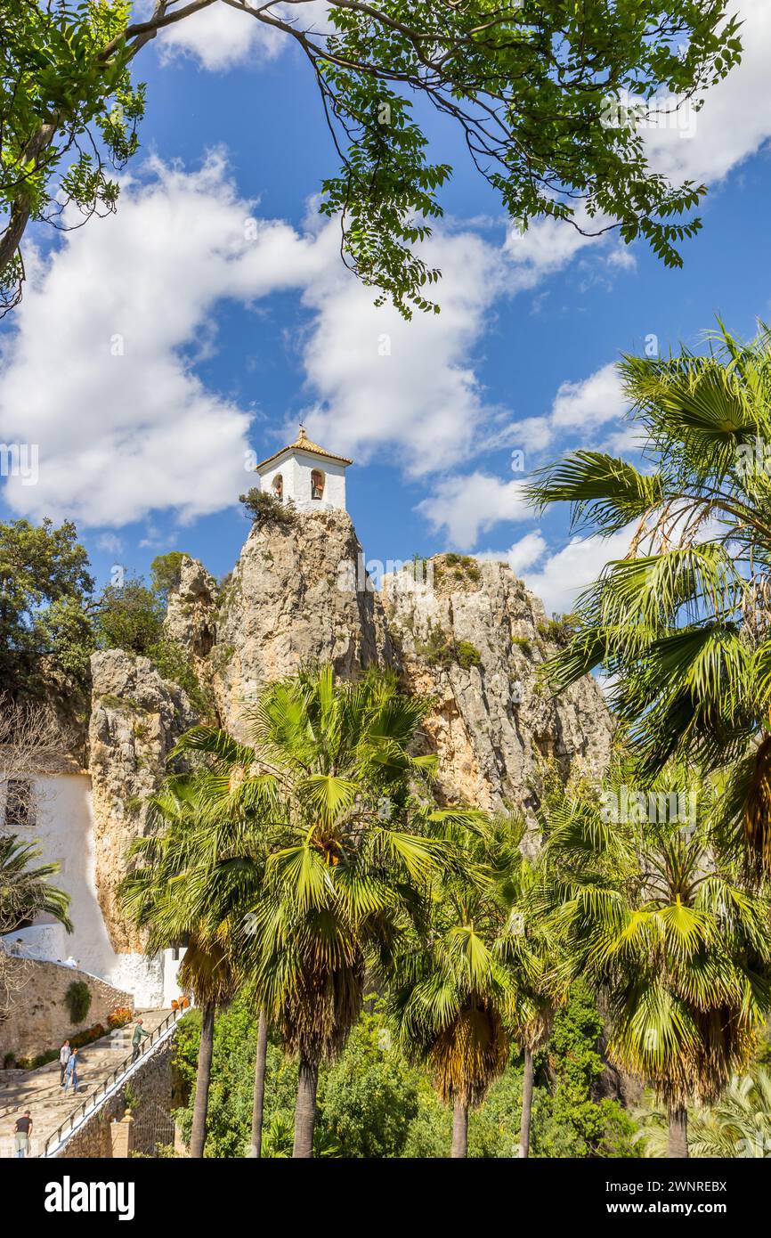 Palm trees in front of the white tower of Guadalest, Spain Stock Photo