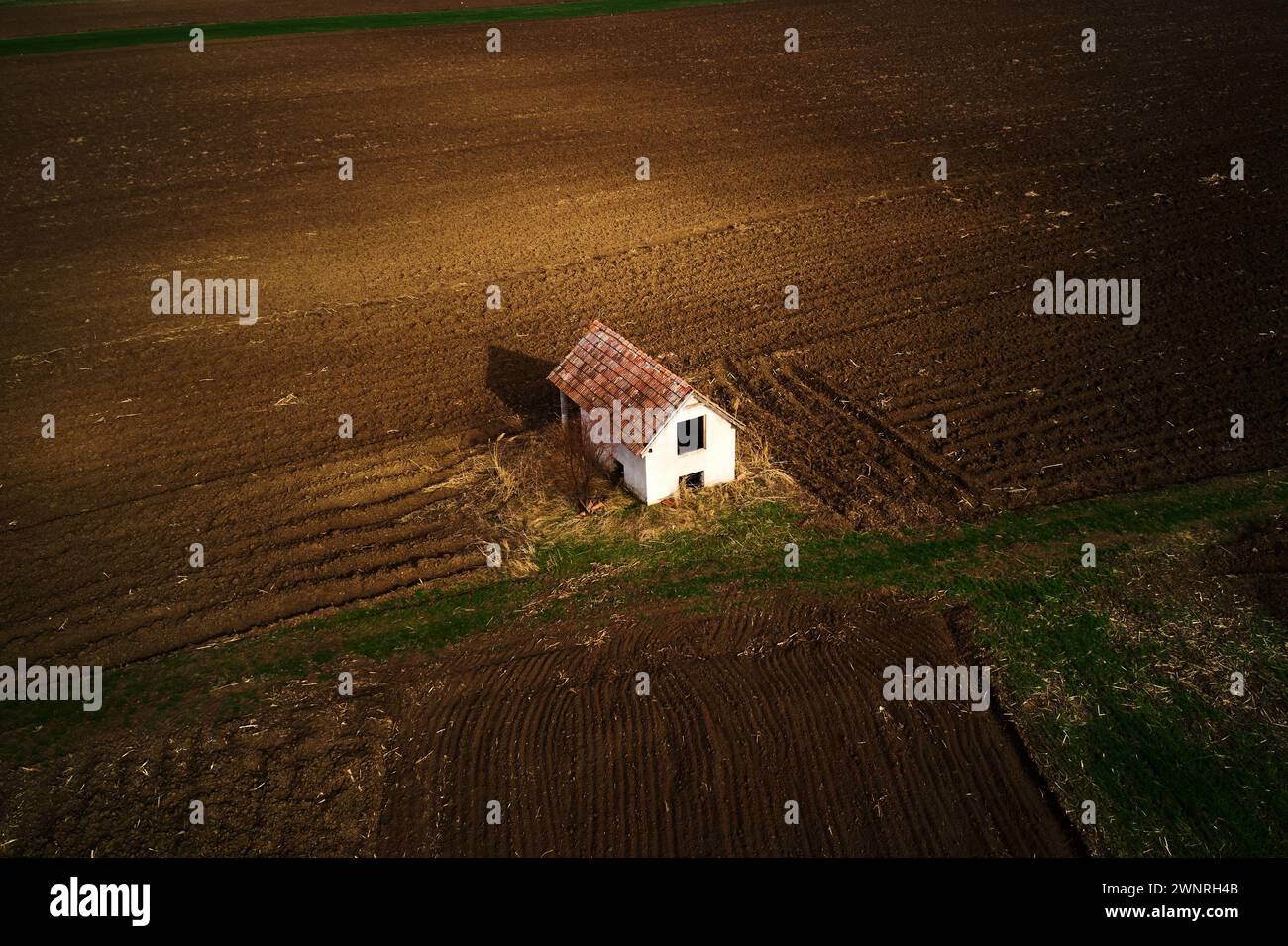 Aerial view of abandoned farmhouse in field, drone pov high angle view Stock Photo